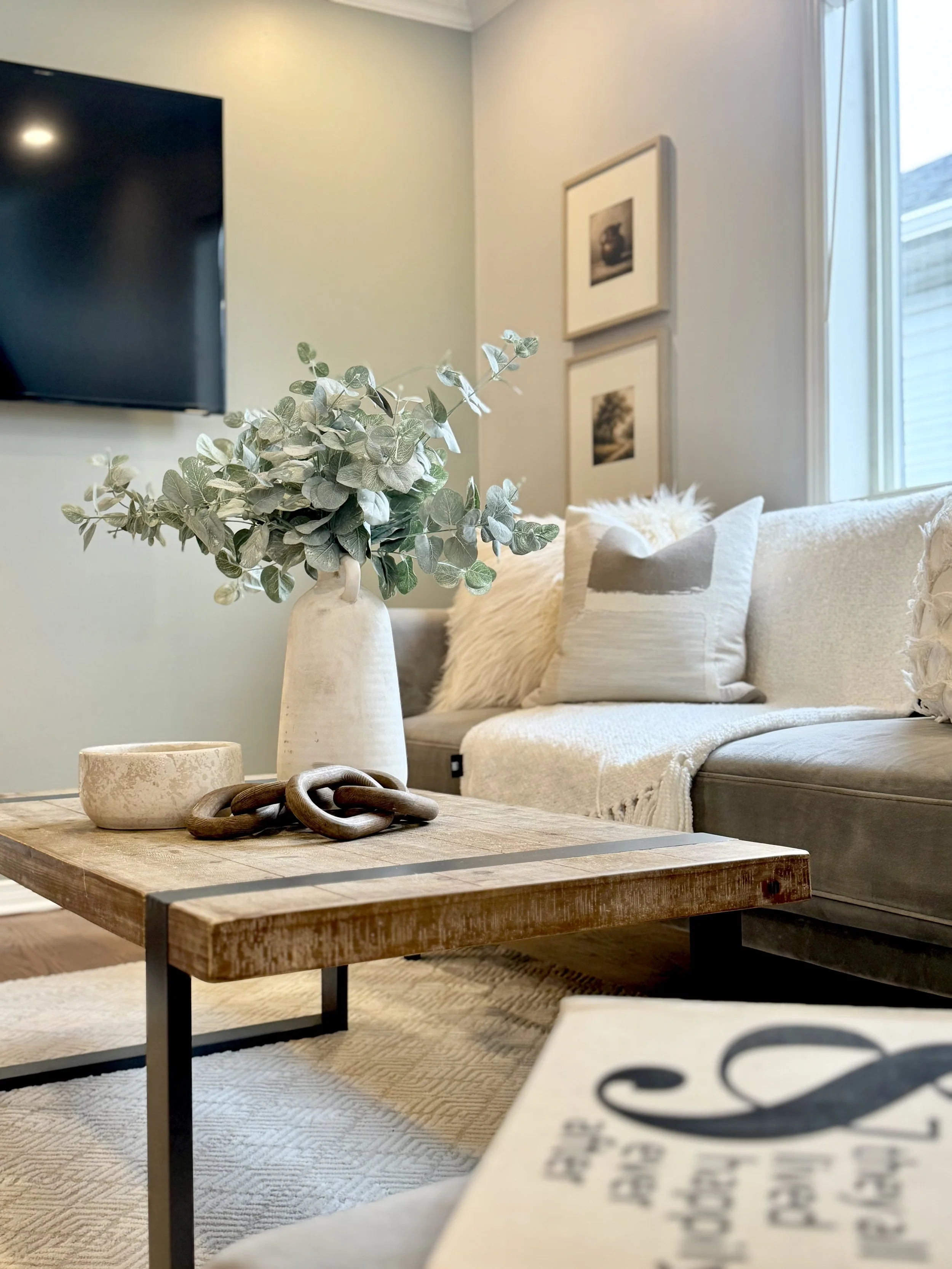 Close view of a styled living room with rental artwork, lighting, textiles, and decorative pieces